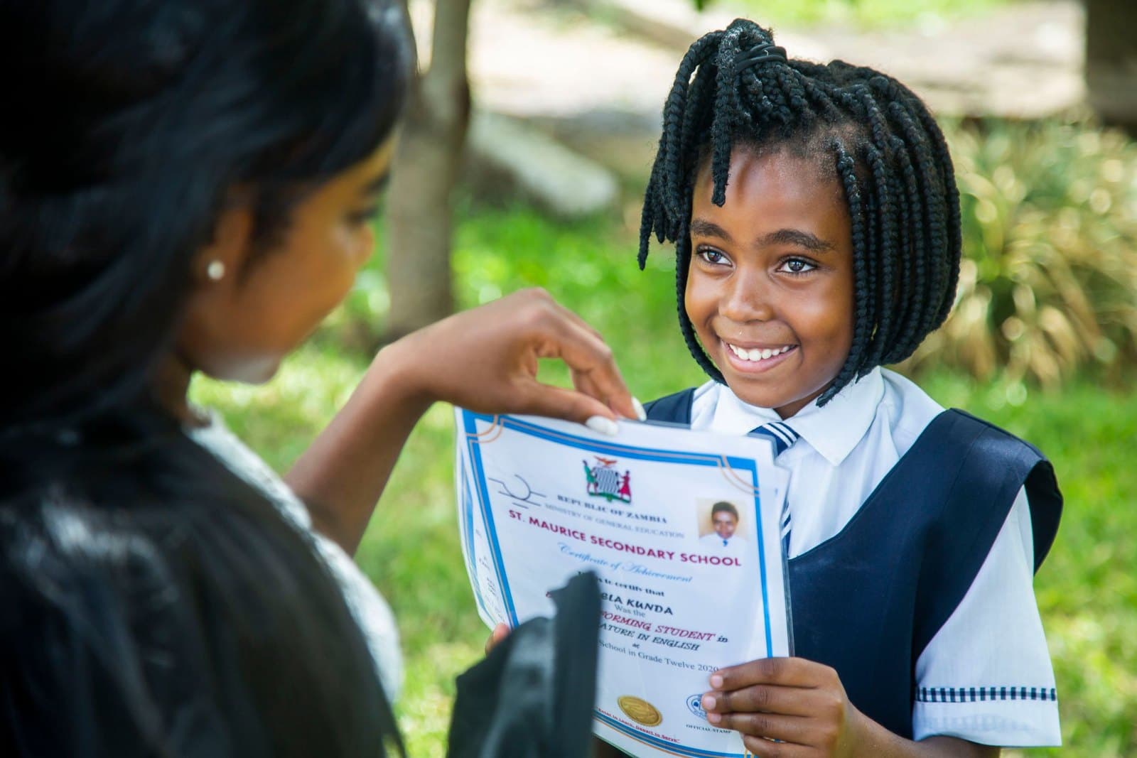 A Nigerian secondary school student in uniform receiving an award